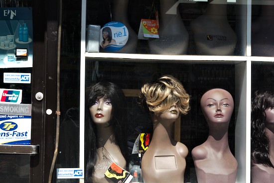 Une vitrine exhibant des têtes d’apprentissage pour coiffeurs.